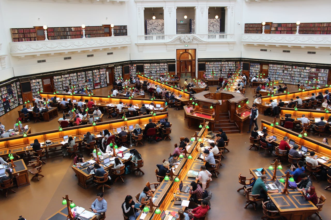 services-03 Aerial view of a bustling study hall in a university library with students studying.