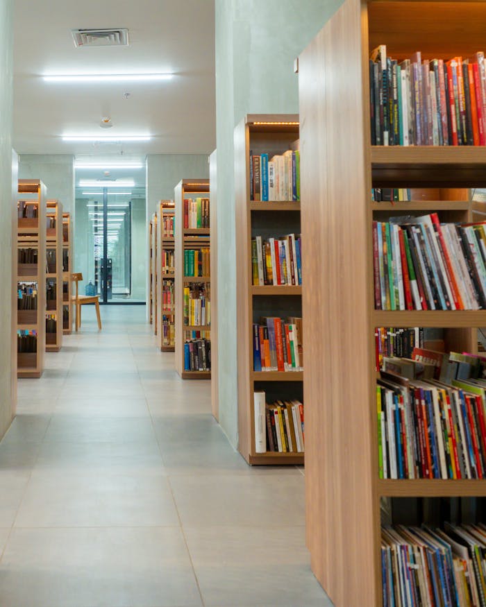 our-experience Spacious library interior with neatly arranged bookshelves in Jakarta.